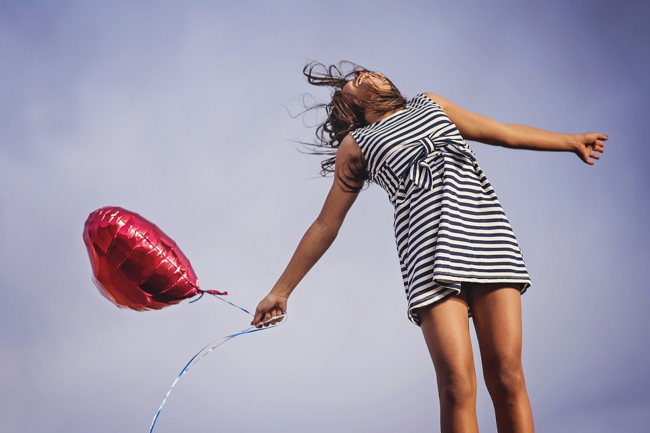 Woman with balloon practicing gratitude to increase positivity